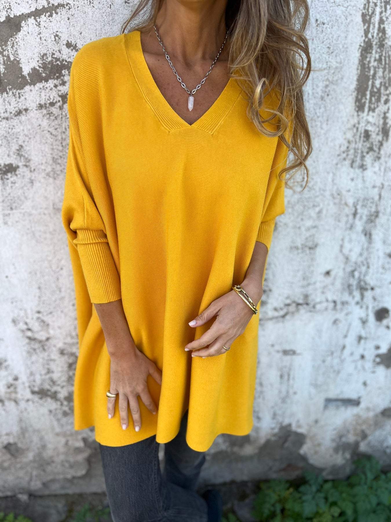 Mustard yellow V-neck pullover sweater with three-quarter sleeves and soft drape.