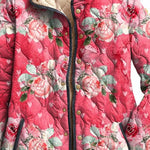 Women's pink floral print quilted jacket close-up with button placket and stand collar