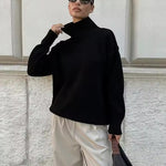Black knit turtleneck sweater with ribbed cuffs and loose fit