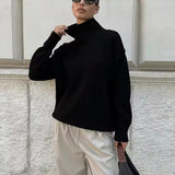 Black knit turtleneck sweater with ribbed cuffs and loose fit