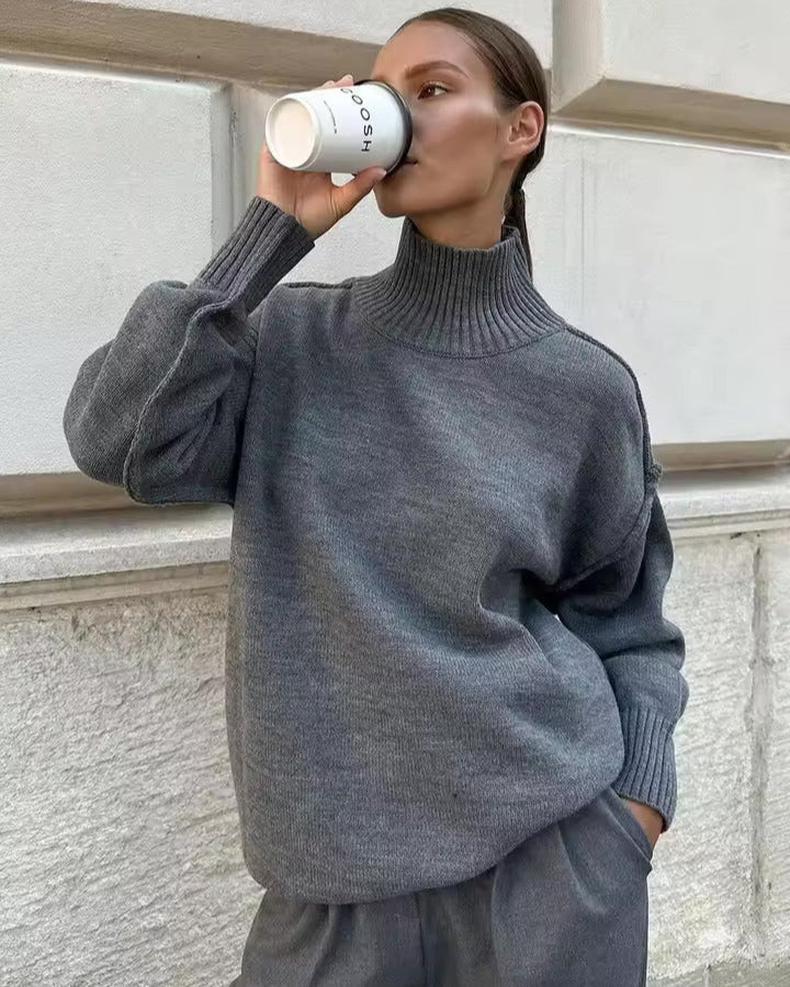 Gray knit turtleneck sweater with long sleeves and ribbed roll collar
