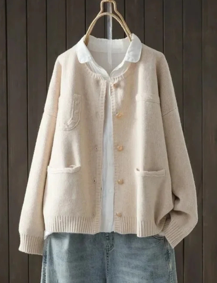 Cream button-front cardigan sweater with stand collar, front pockets, ribbed cuffs
