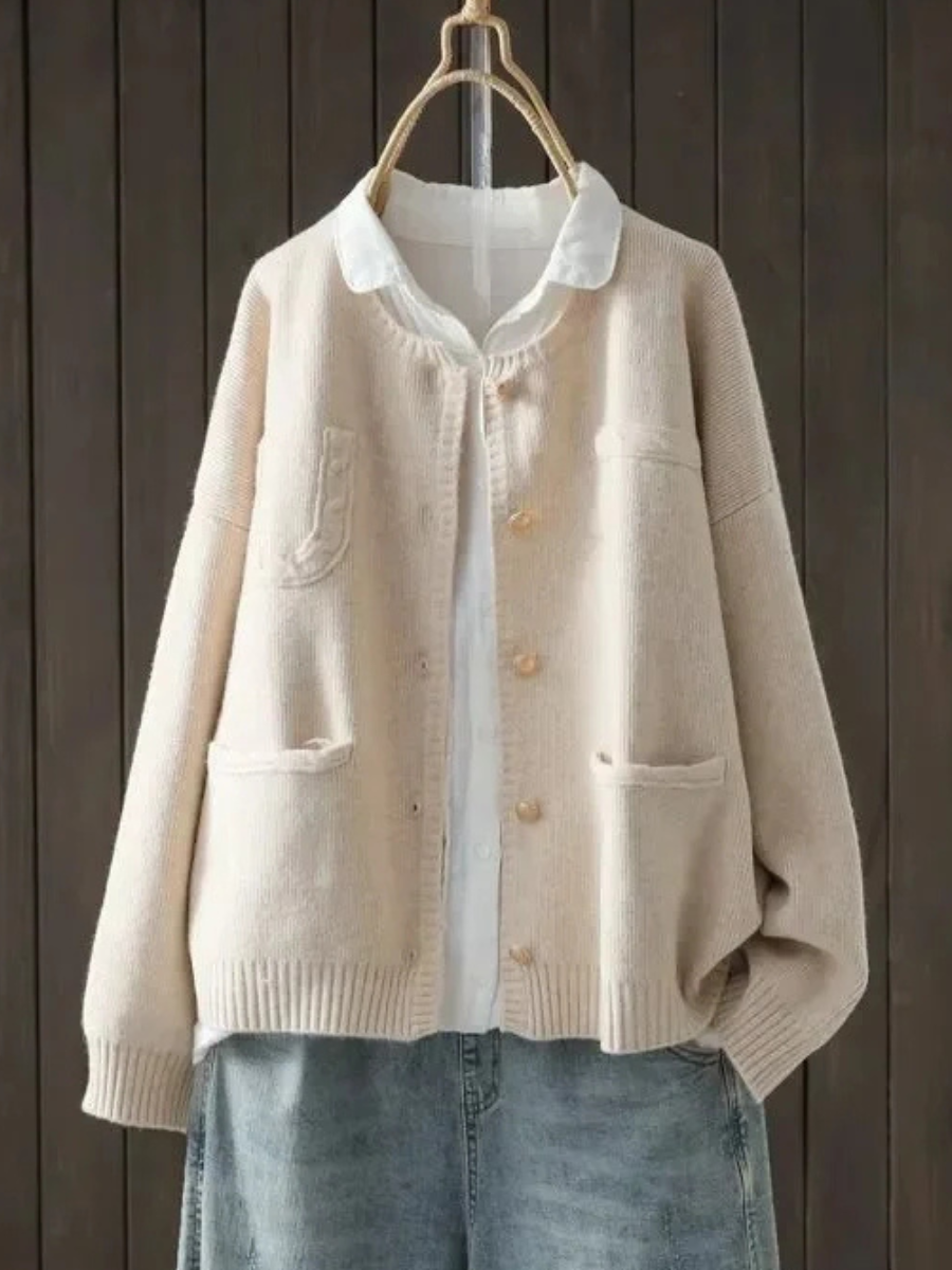 Cream button-front cardigan sweater with stand collar, front pockets, ribbed cuffs