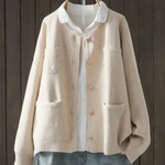 Cream button-front cardigan sweater with stand collar, front pockets, ribbed cuffs