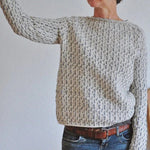 Speckled knit sweater with ribbed crew neck, long sleeves, and relaxed fit