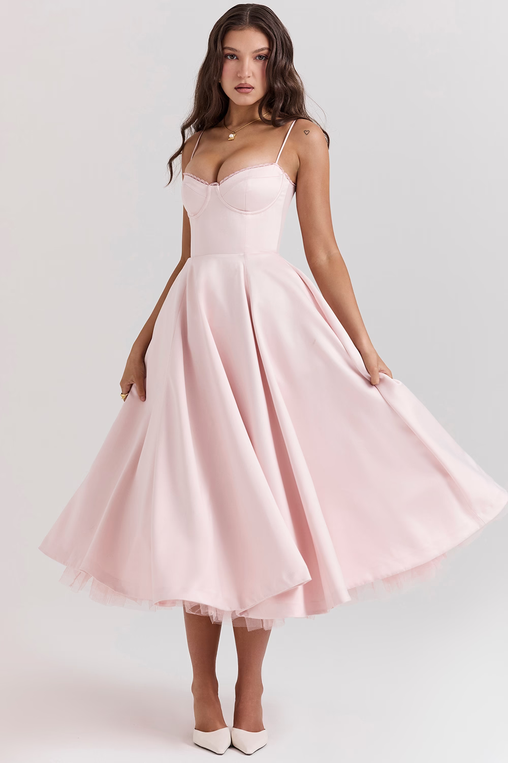 Blush pink sleeveless corset dress with thin straps and swingy flared midi skirt