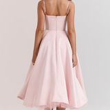 Blush pink back view corset-style dress with spaghetti straps and flared midi skirt