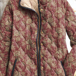 Women's vintage floral jacket close-up, maroon patterned fabric with gold buttons and collar