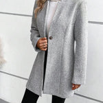 Grey collarless long-sleeve overcoat with herringbone texture and button-front opening