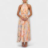 Watercolor halter maxi dress with pastel orange, blue, and yellow print