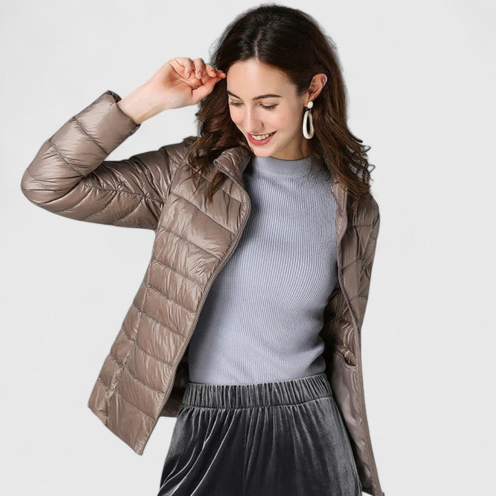Taupe quilted puffer jacket with zip front and stand collar, model wearing