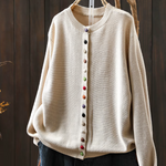 Cream knit cardigan with round neckline, button-front placket and long sleeves.