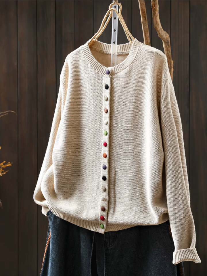 Cream knit cardigan with round neckline, button-front placket and long sleeves.