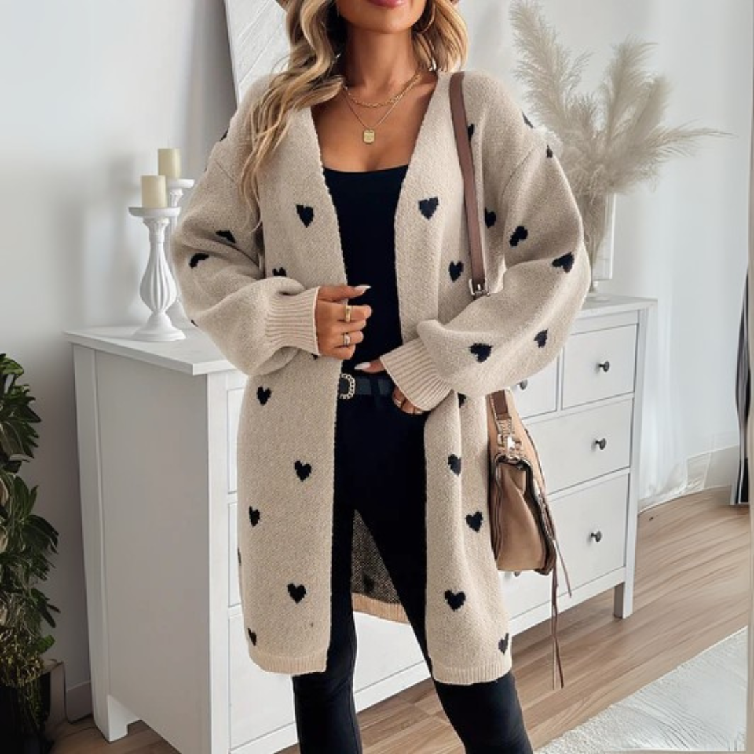 Beige heart-pattern cardigan with open front and long sleeves, black hearts