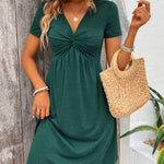 Green short-sleeve dress with twisted V-neck and gathered skirt