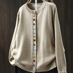 Cream cardigan sweater with multicolor button front and ribbed crew neckline