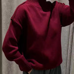 Burgundy knit turtleneck sweater with long sleeves and ribbed collar