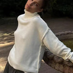 White knit turtleneck sweater with long sleeves and ribbed shoulder detail