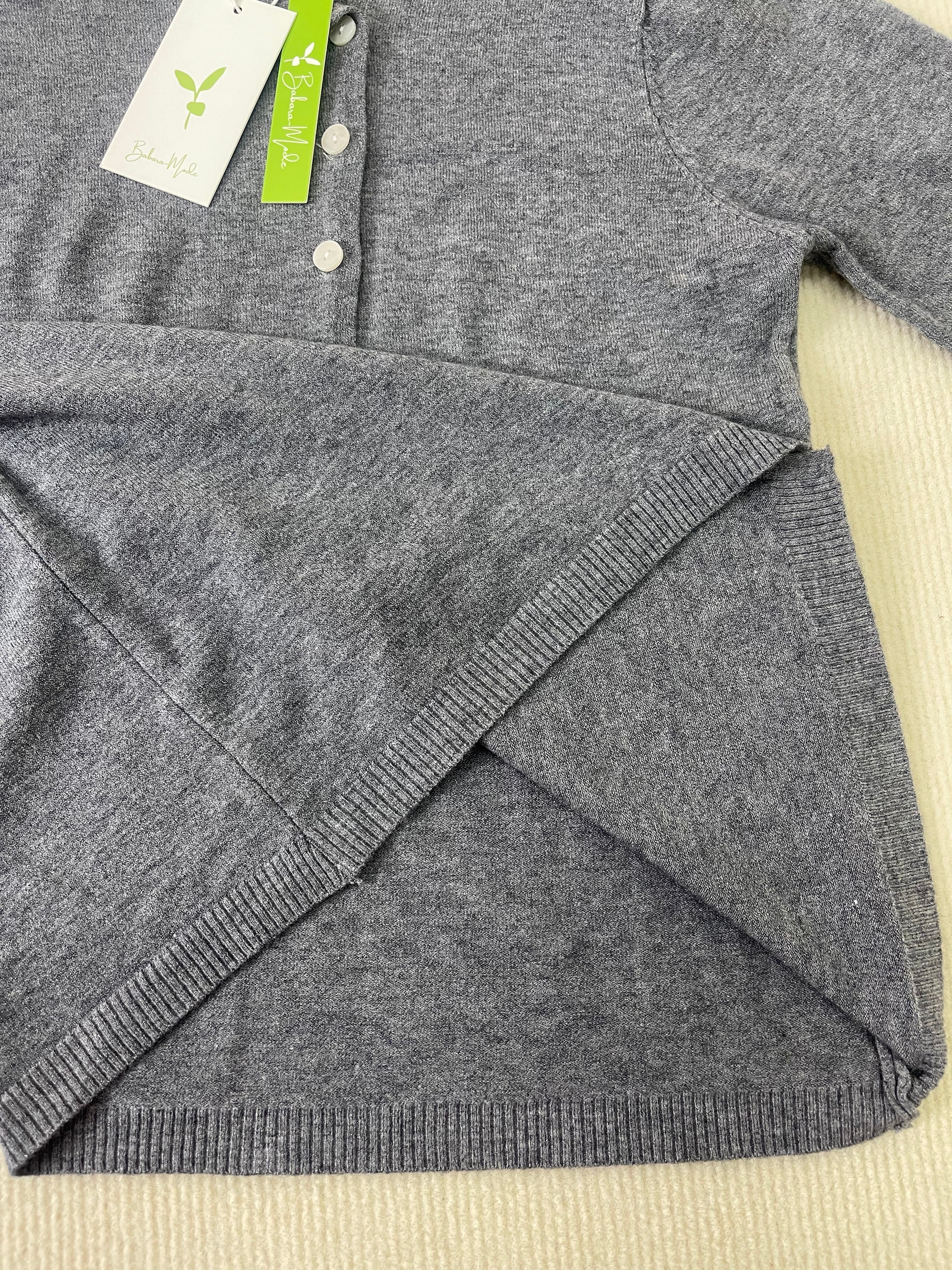 Grey heather knit pullover sleeve and hem with ribbed trim, button placket visible