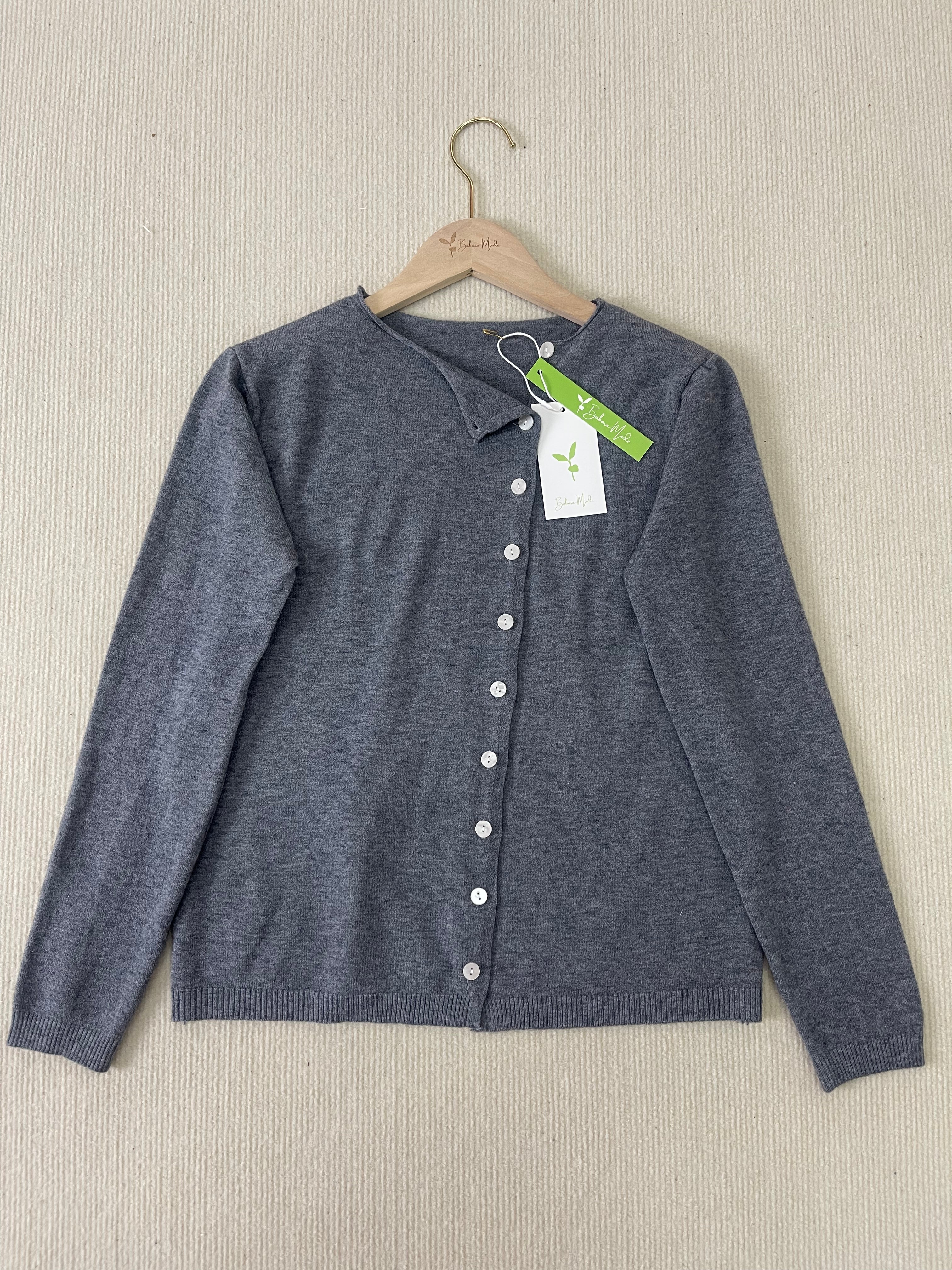 Grey button-front knit pullover with V-neck and long sleeves on hanger