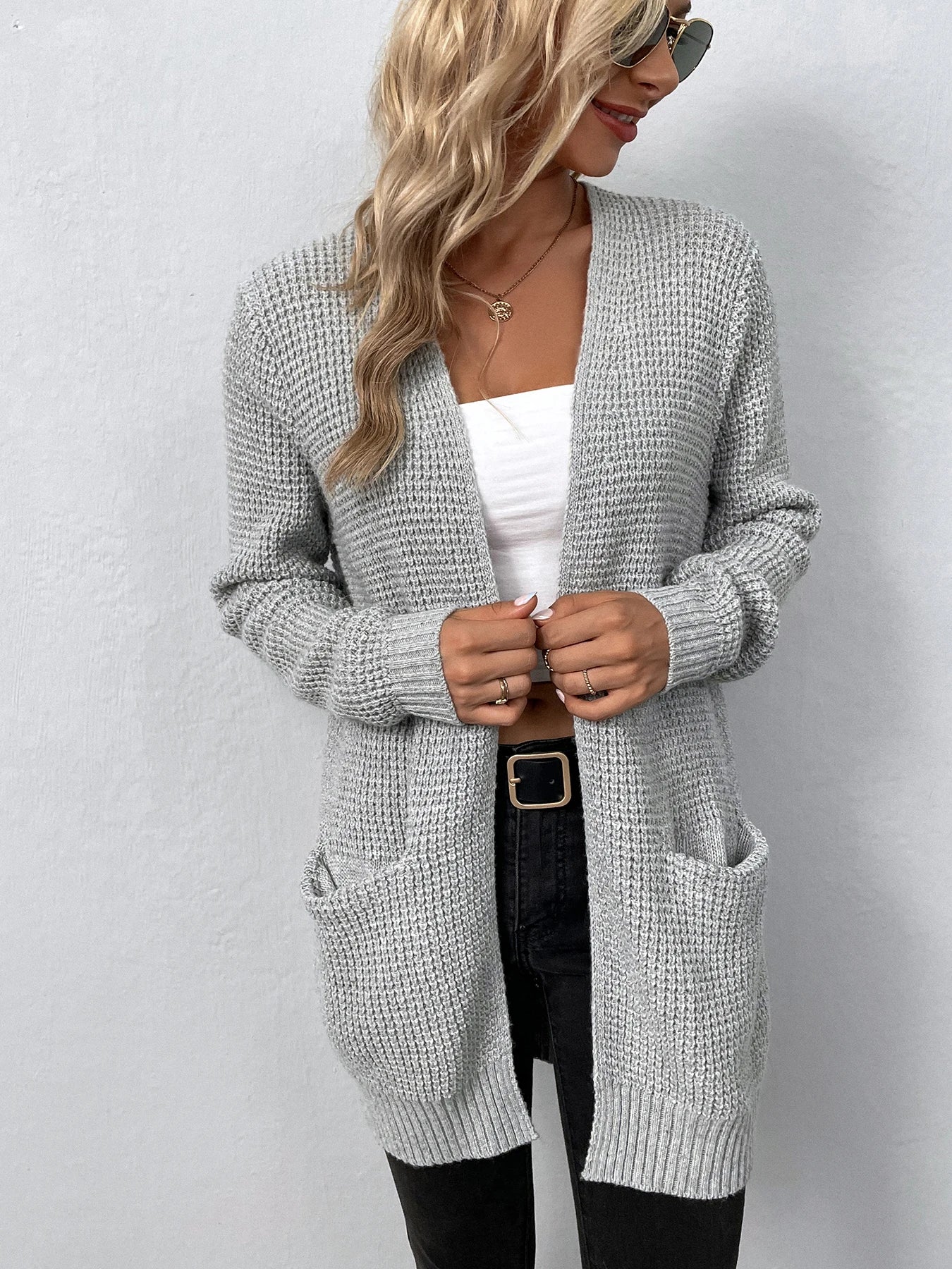Light gray knit cardigan with open front, long sleeves, and visible front pockets