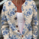 Floral button pullover sweater with cream base, blue blossoms, round neckline, brown buttons