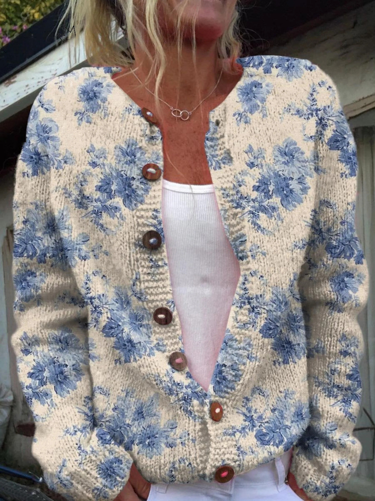 Floral button pullover sweater with cream base, blue blossoms, round neckline, brown buttons