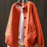 Orange cable-knit cardigan with button front and textured knit sleeves