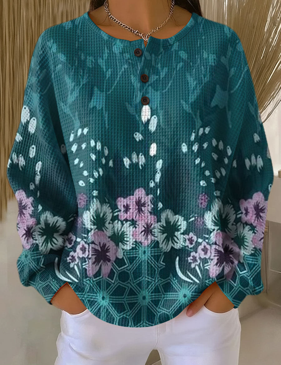 Teal floral print pullover with round neckline and button placket, loose long sleeves