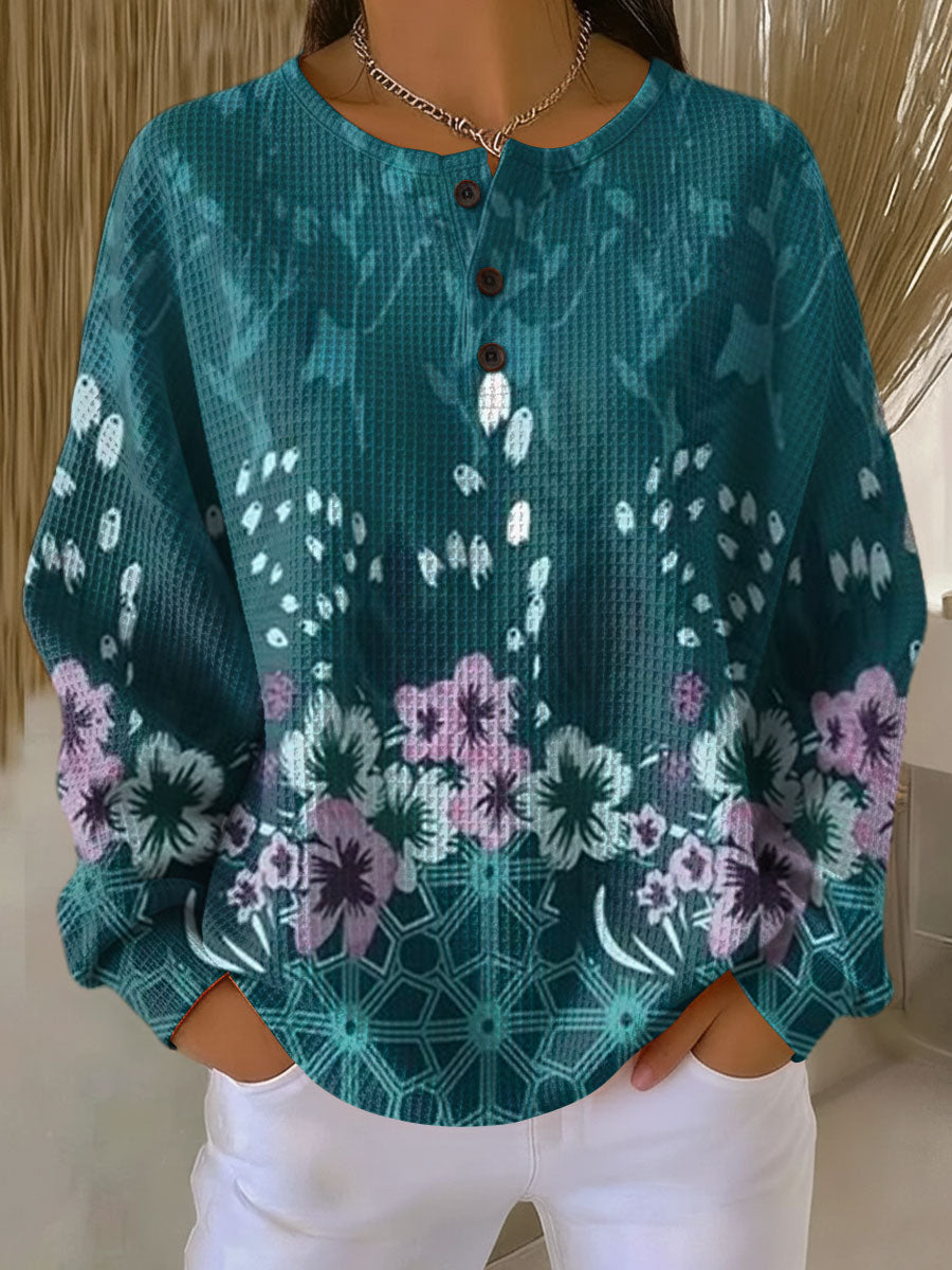 Teal floral print pullover with round neckline and button placket, loose long sleeves