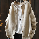 Cream structured cardigan with button front and ribbed cuffs, textured knit fabric