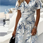 White midi dress with blue botanical print, V-neck, short sleeves, tied waist