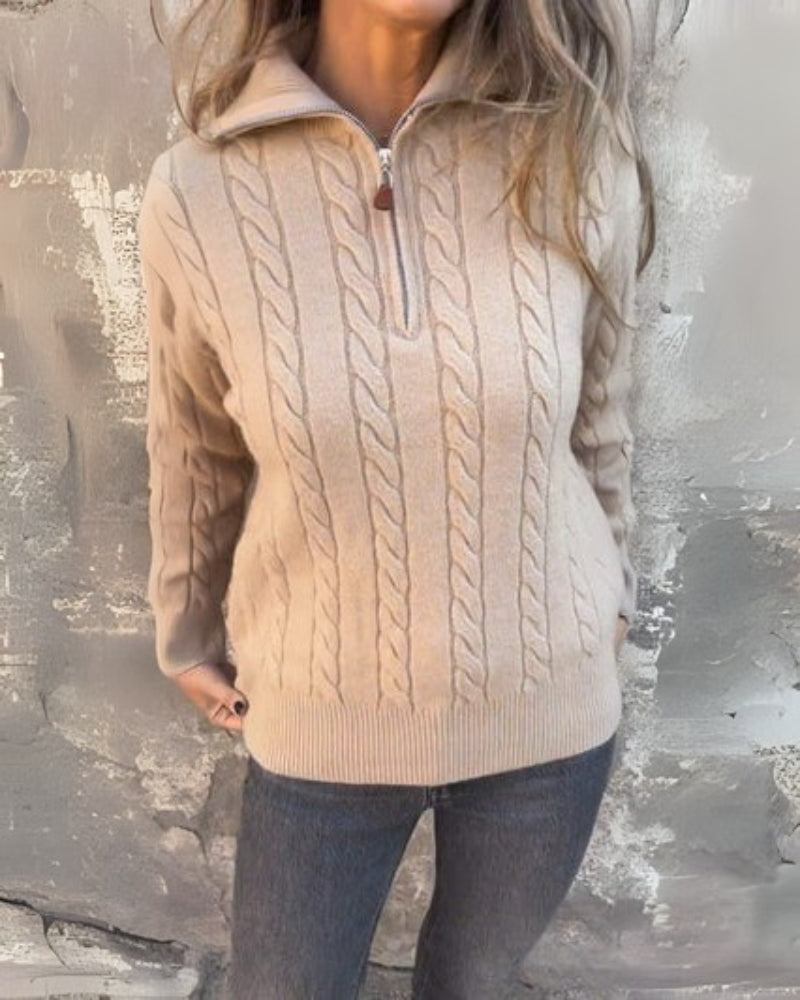 Beige cable-knit half-zip pullover with long sleeves and ribbed cuffs, zipper front
