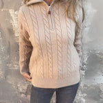 Beige cable-knit half-zip pullover with long sleeves and ribbed cuffs, zipper front