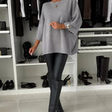 Loose gray knit pullover with wide three-quarter sleeves and ribbed cuffs