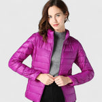 Purple quilted puffer jacket with full zip and stand collar, model wearing