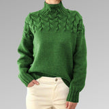 Women's cable-knit turtleneck sweater, green with raised cable front and cuffs.
