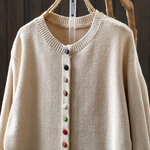 Beige knit cardigan with ribbed collar and multicolor button-front placket.