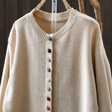 Beige knit cardigan with ribbed collar and multicolor button-front placket.