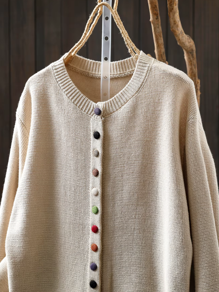Beige knit cardigan with ribbed collar and multicolor button-front placket.