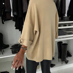 Beige knit pullover back view with wide sleeves and loose fit, ribbed hem