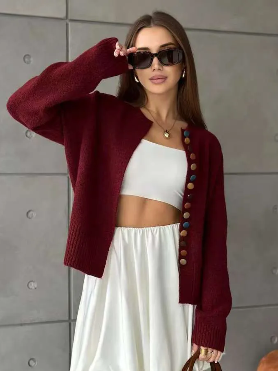 Wine red knit cardigan with multicolor button placket and long sleeves, worn open