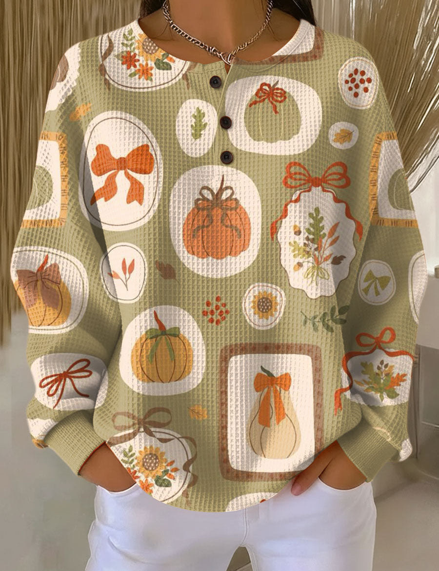 Light green knit sweater with colorful bow and pumpkin motifs, button-front round neck, long sleeves