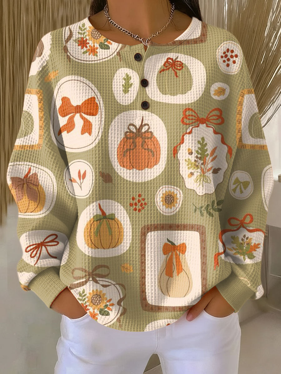 Light green knit sweater with colorful bow and pumpkin motifs, button-front round neck, long sleeves