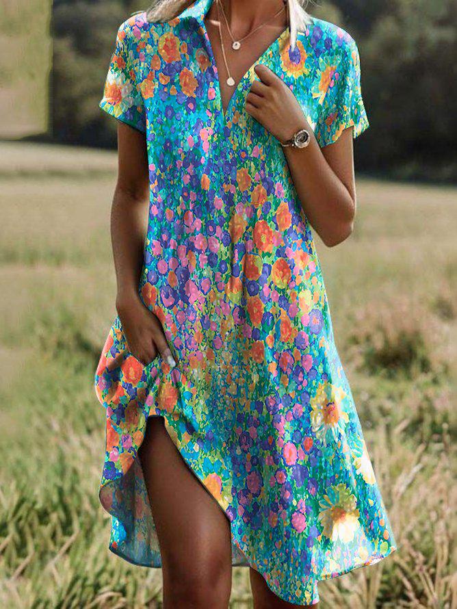 Floral short-sleeve summer dress on a teal-blue base with multicolor print and side slit.