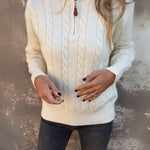 Cream cable-knit half-zip pullover with long sleeves and ribbed cuffs, zipper front
