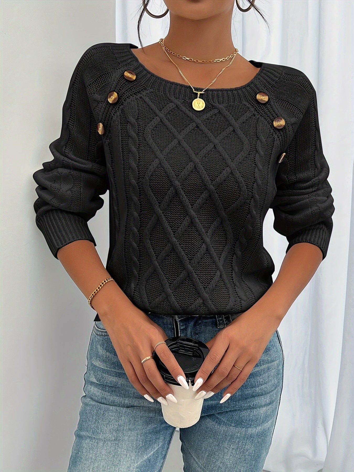 Black cable-knit crewneck sweater with decorative shoulder buttons and ribbed cuffs