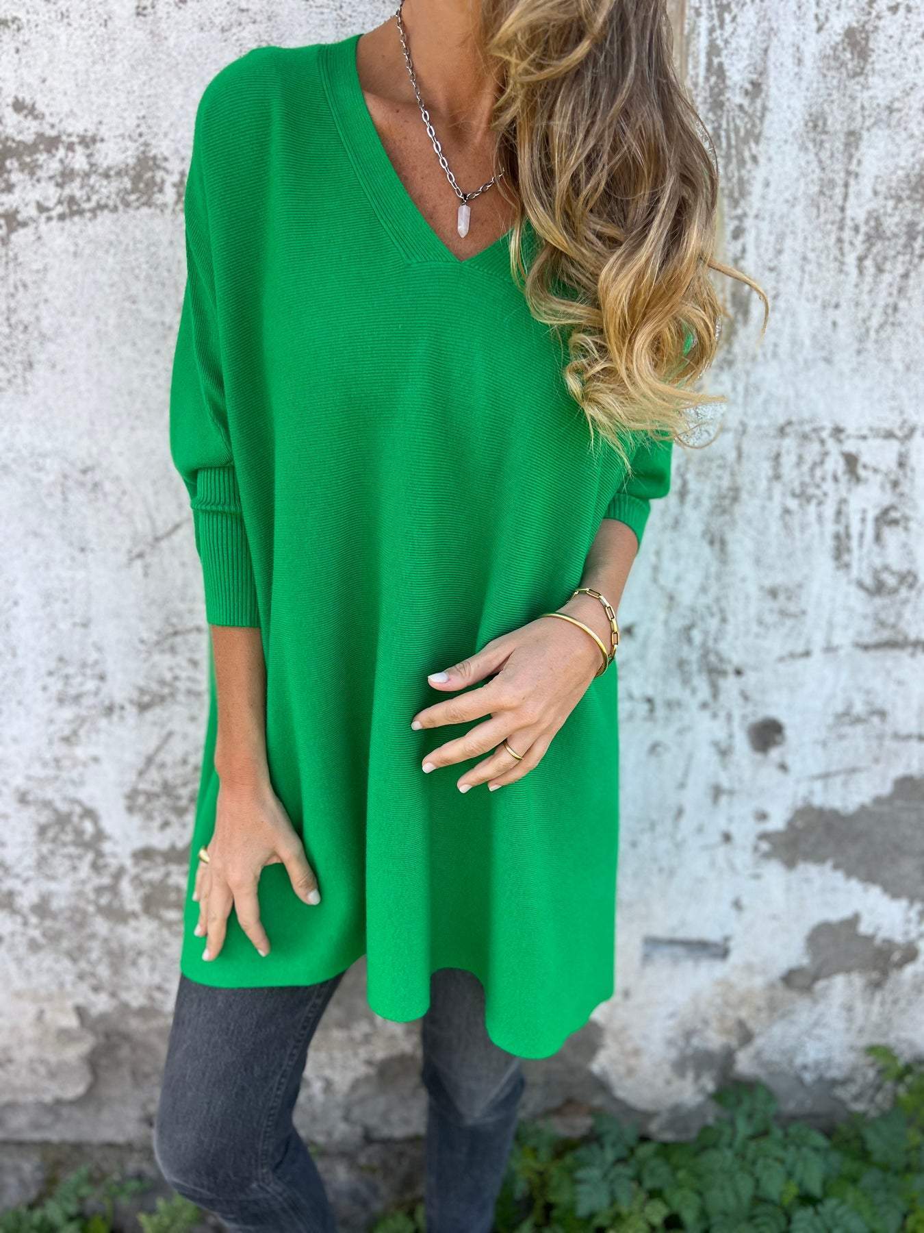 Green V-neck pullover sweater with three-quarter sleeves and loose, tunic-style fit.