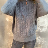 Dark gray cable-knit half-zip pullover with textured cable pattern and ribbed hem