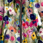 Quilted floral jacket detail with multicolor buttons and cream stand collar.